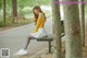 A woman sitting on a bench in a park.