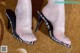 A close up of a woman's feet wearing a pair of black and white shoes.