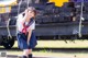 A woman in a school uniform standing on a train track.