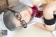 A woman with gray hair wearing glasses laying on a table.