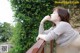 A woman leaning on a railing with her hand on her chin.