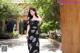 A woman in a black and white dress standing in a courtyard.