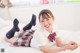 A young woman laying on a bed with a teddy bear.